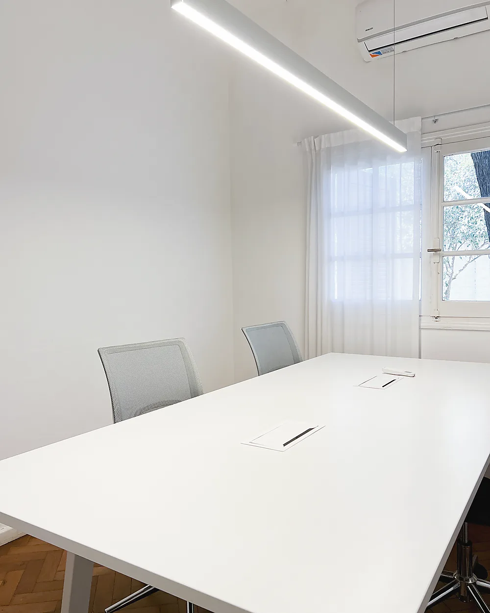 Oficina privada de Lätt con mesa de reuniones y luz natural