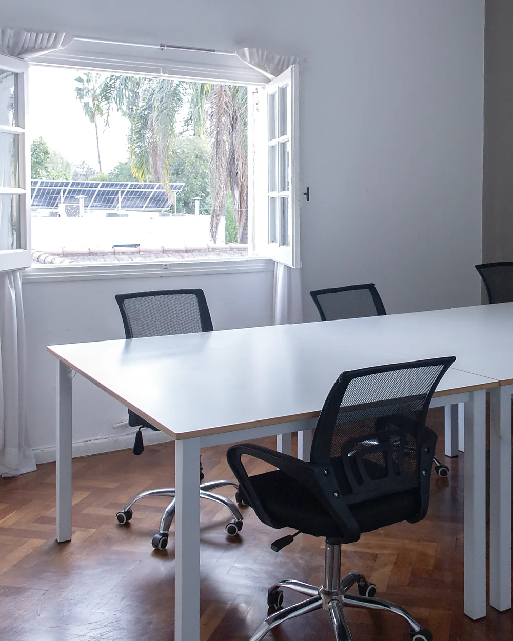 Oficina privada de Lätt con mesa para varios puestos y ventana con vista al parque